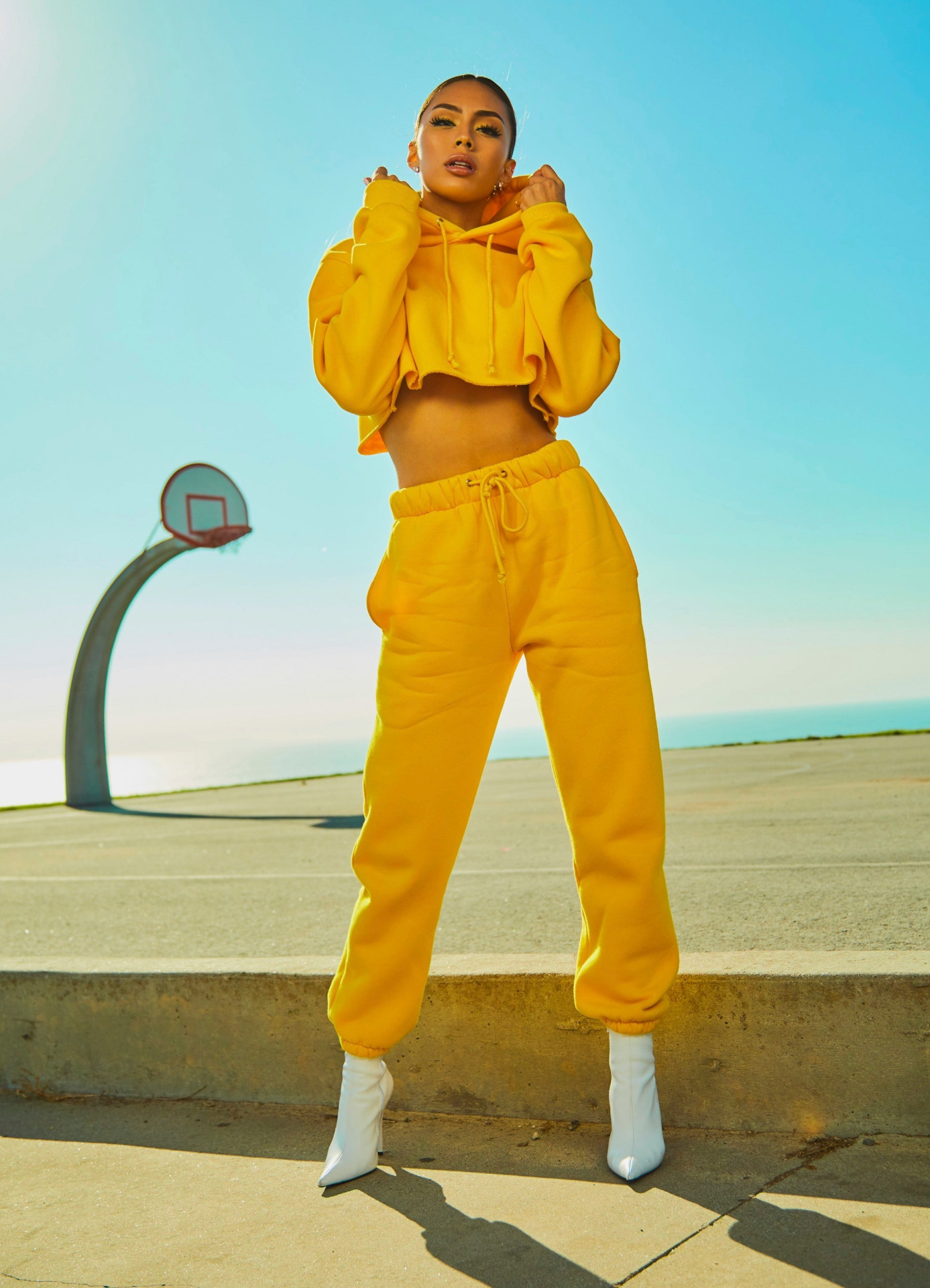 Fashion editorial of a model in a bright yellow tracksuit outdoors
